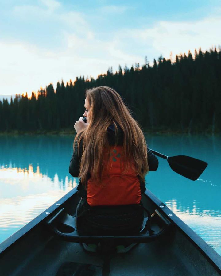 Someone paddling a canoe on a misty lake